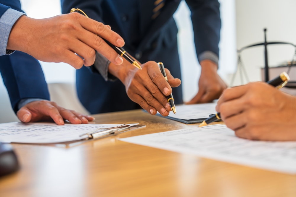 a team meeting where people are pointing at a document using their hands